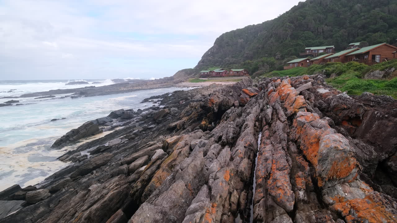 Storms River rest camp wooden cabins on rocky shoreline, Tsitsikamma