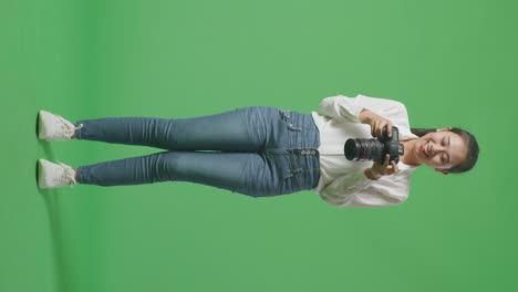 woman taking a photo on green screen