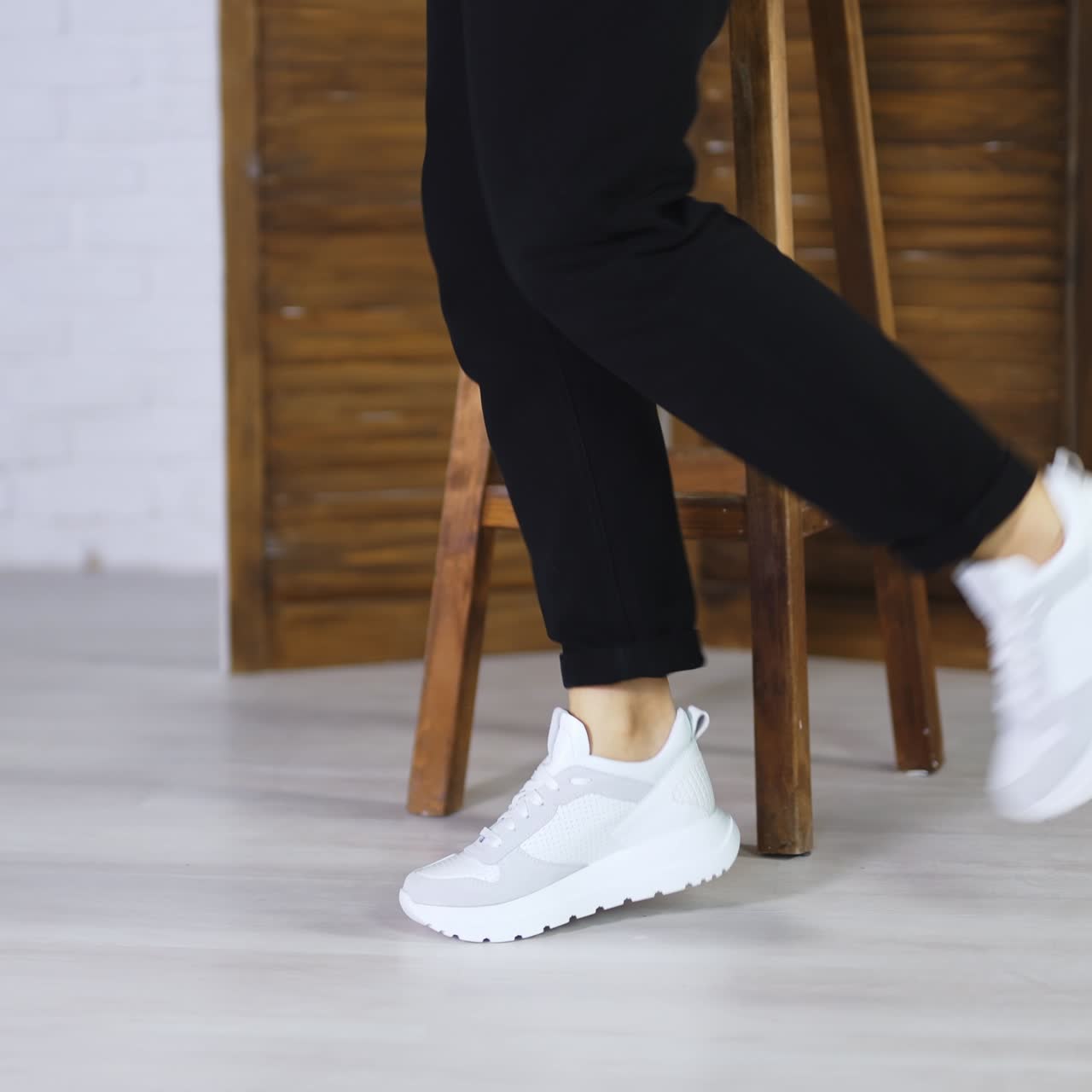 Dancing in a new white comfortable sneakers with laces. Female model jumps to demonstrate fashionable sport footwear