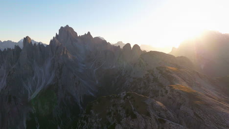 glowing sunlit tre cime mountain peaks and summit aerial view across south tyrol shining sunrise panorama