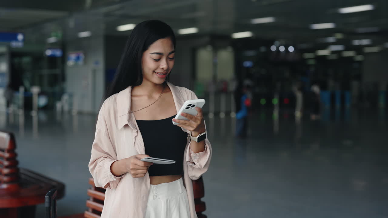 Woman using smartphone in train station