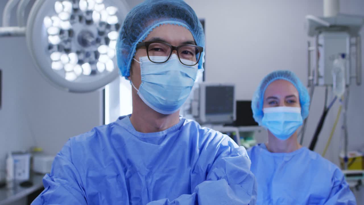 Diversos cirujanos y cirujanas caucásicos con mascarillas y ropa protectora en un hospital.