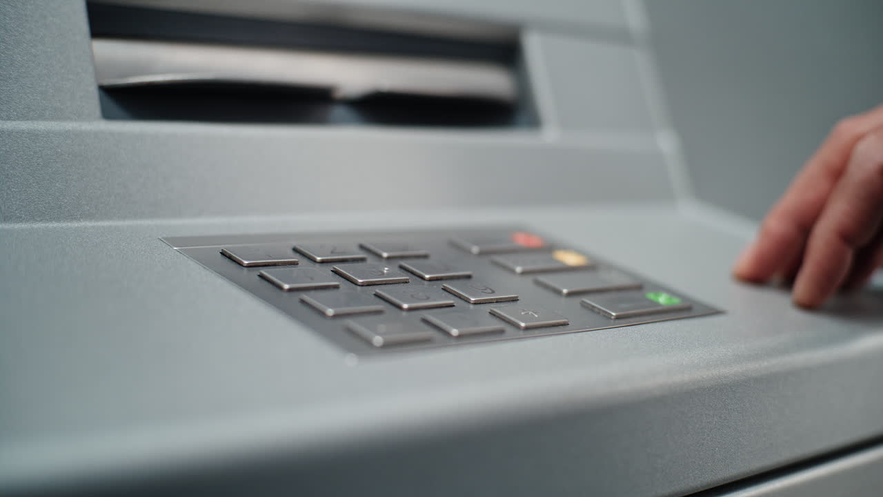 Person using ATM keypad