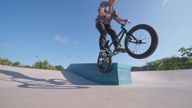Giovane uomo che esegue un trick in BMX su rampa in uno skatepark