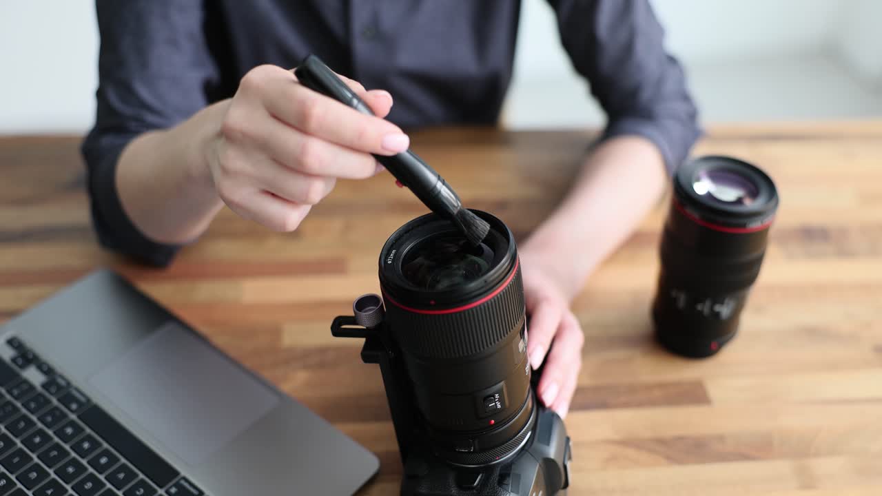 Pulizia dell'obiettivo della fotocamera con una spazzola