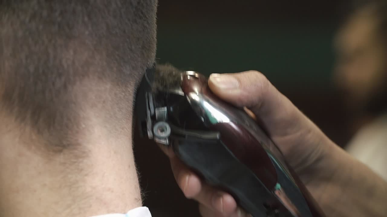 Close-up of a hair clipper trimming hair on the back of a person's head