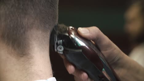 close-up of a hair clipper trimming hair on the back of a person's head