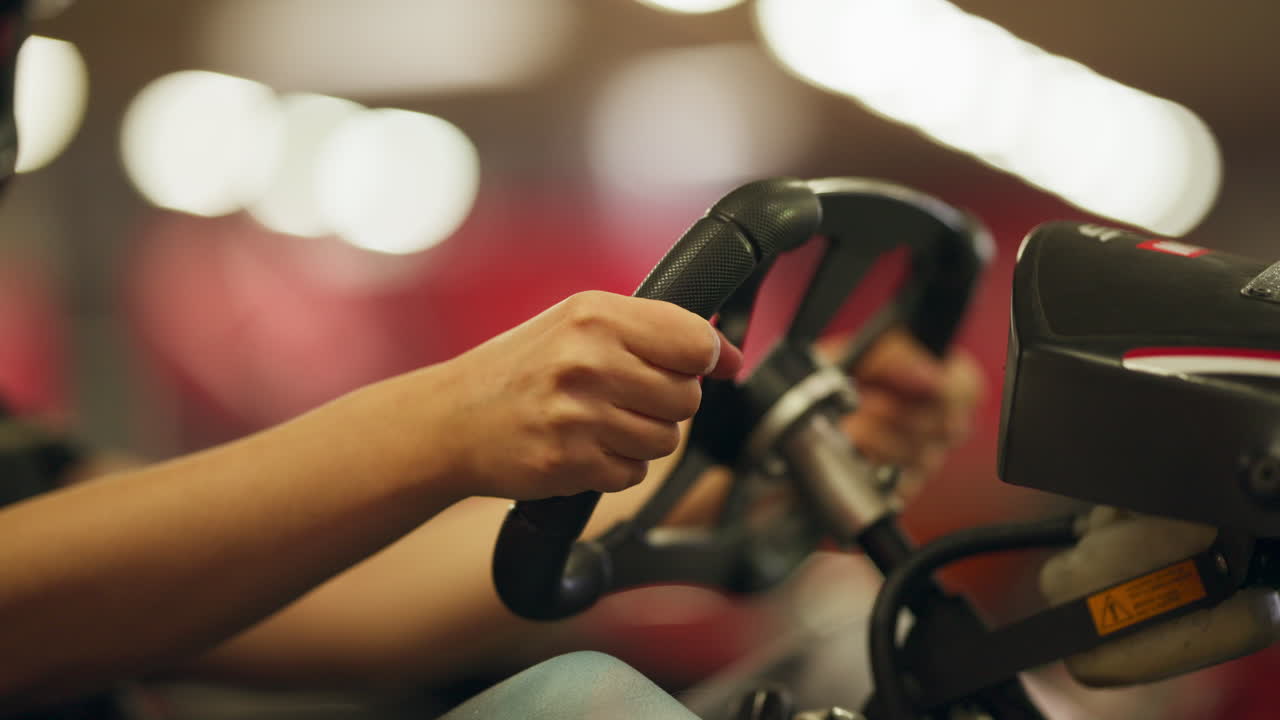 Close up shot of boy's hands grabbing the wheel of a kart, handheld