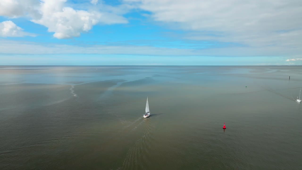 Yacht On Calm Water On Sunny Day With Reflections Of Clouds Lighting Water. River Wyre Estuary, Fleetwood, Lancashire, UK