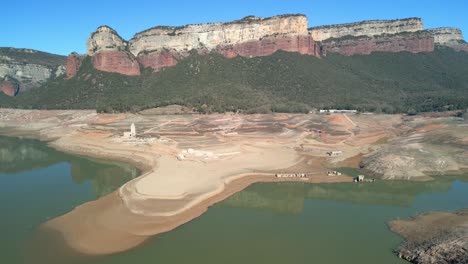 Dique-Del-Pantano-De-Sau-En-Cataluña,-España,-Intensa-Sequía-En-2024-Vuelo-De-Drones-Sobre-Tierras-Desérticas,-Lago-Seco-En-España-Pantano-De-Sau