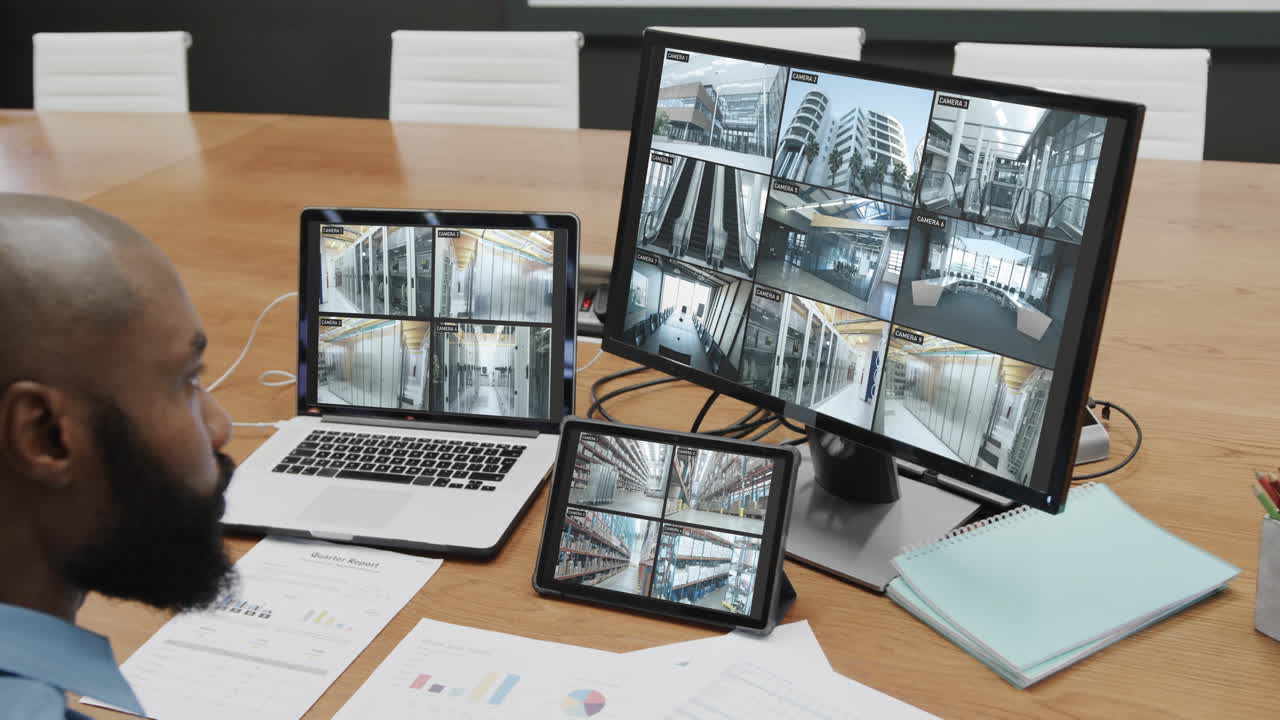 oficial de seguridad afroamericano con negocios cámaras de cctv vistas en tres pantallas, cámara lenta