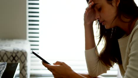 mujer usando teléfono móvil en el sofá en la sala de estar 4k