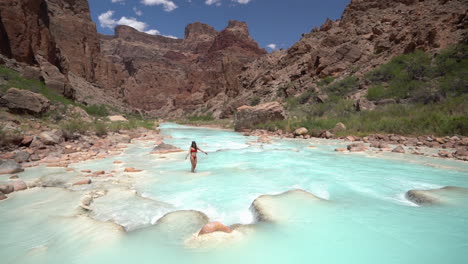 young woman in bikini enjoying in turquoise river water, stunning oasis in grand canyon national park, arizona usa, slow motion