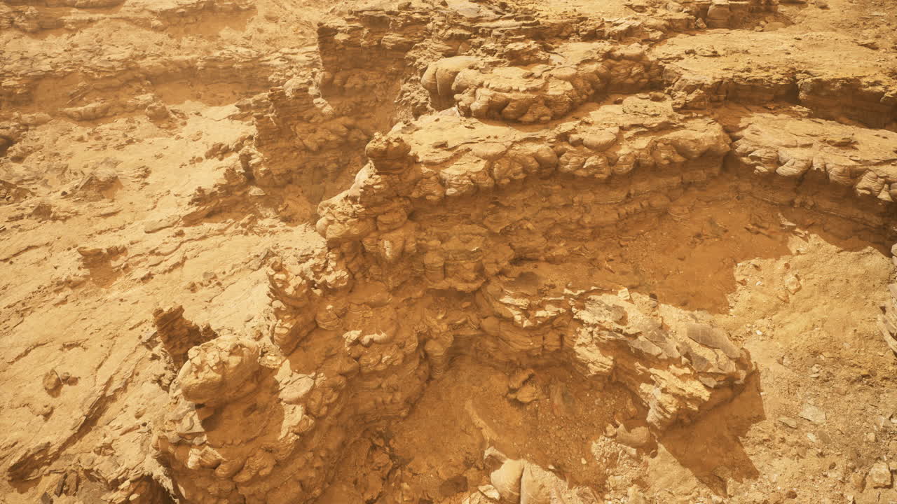 Unique geological formations in a dry desert landscape during midday