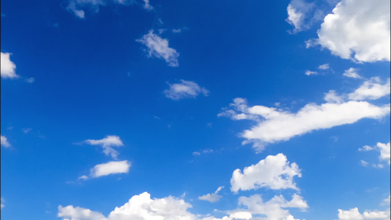 Amazing blue sky in summer with clouds transforming. Low angle view at the horizon with soft little clouds. Timelapse.