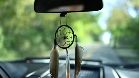 dream catcher attached to the rearview mirror of a pickup truck