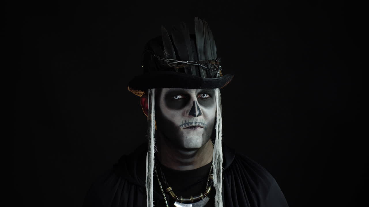 hombre espeluznante con maquillaje de esqueleto. tipo girando la cabeza y mirando a la cámara, tratando de asustar