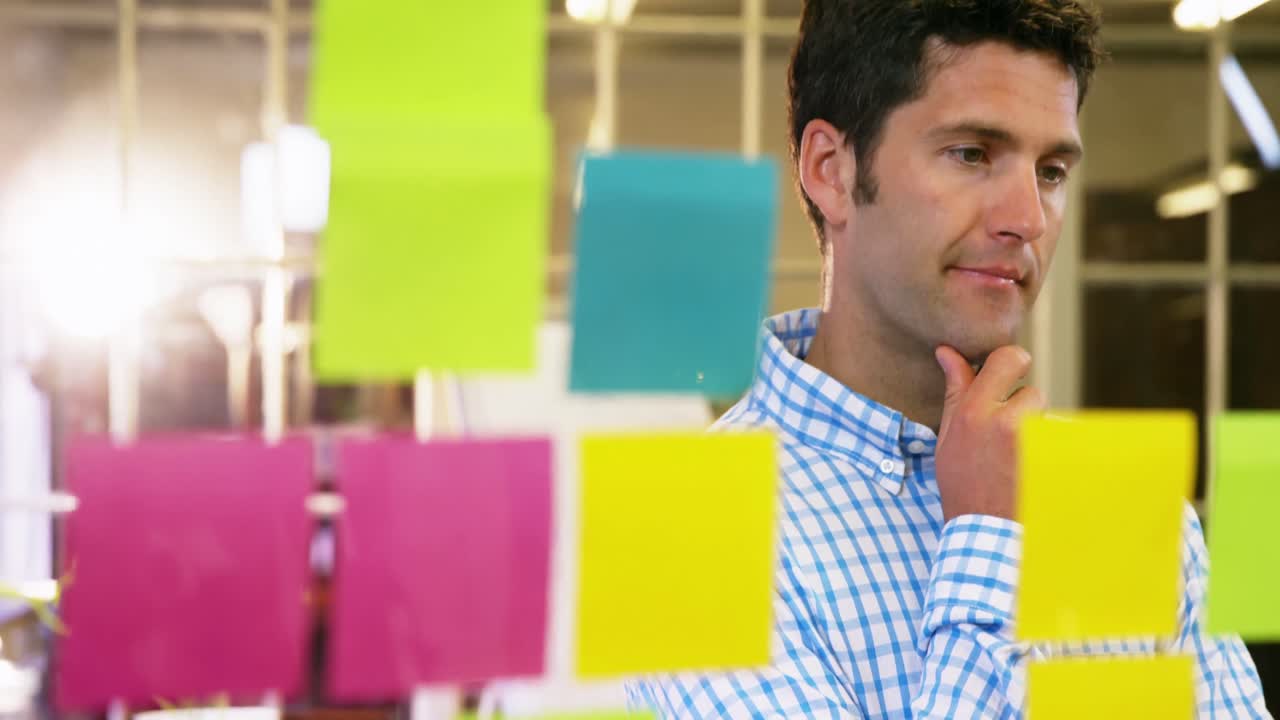 ejecutivo de negocios masculino mirando notas adhesivas