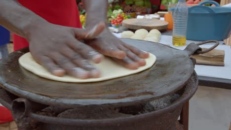 cropped view of ugandan man making egg street food dish called rolex