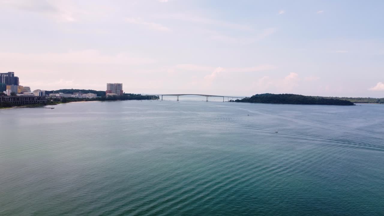 Aerial establishing view of bridge connecting Sihanoukville city to island, surrounded by water and coastline