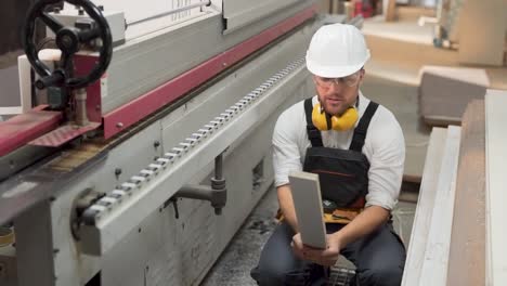 an angry worker in uniform knocks himself at the helmet