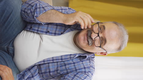 Vertical-video-of-Happy-talking-old-man-on-the-phone.