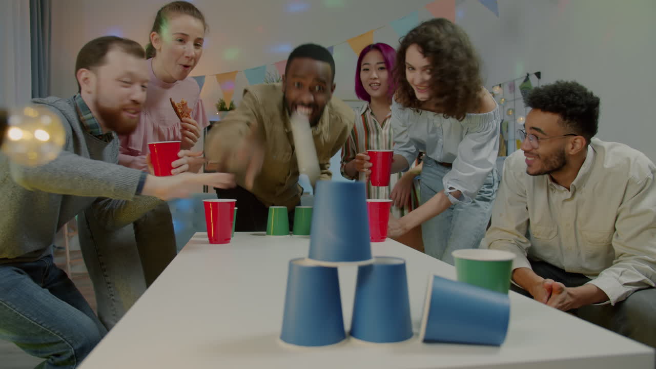 Friends Playing a Cup Stacking Game at a Party