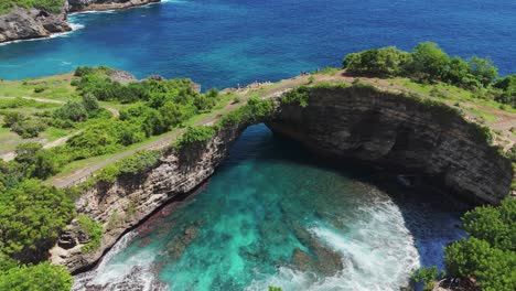 turquoise cove and natural arch at broken beach aerial static establishing of vibrant ocean colors in bali