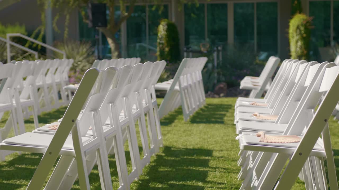 césped verde con filas de sillas de madera