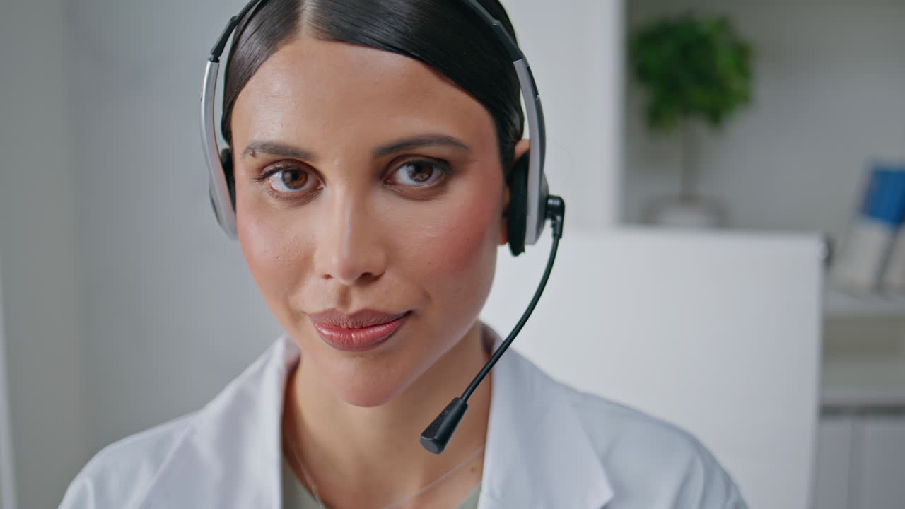 Telehealth specialist talking headset in medical office closeup. Woman doctor