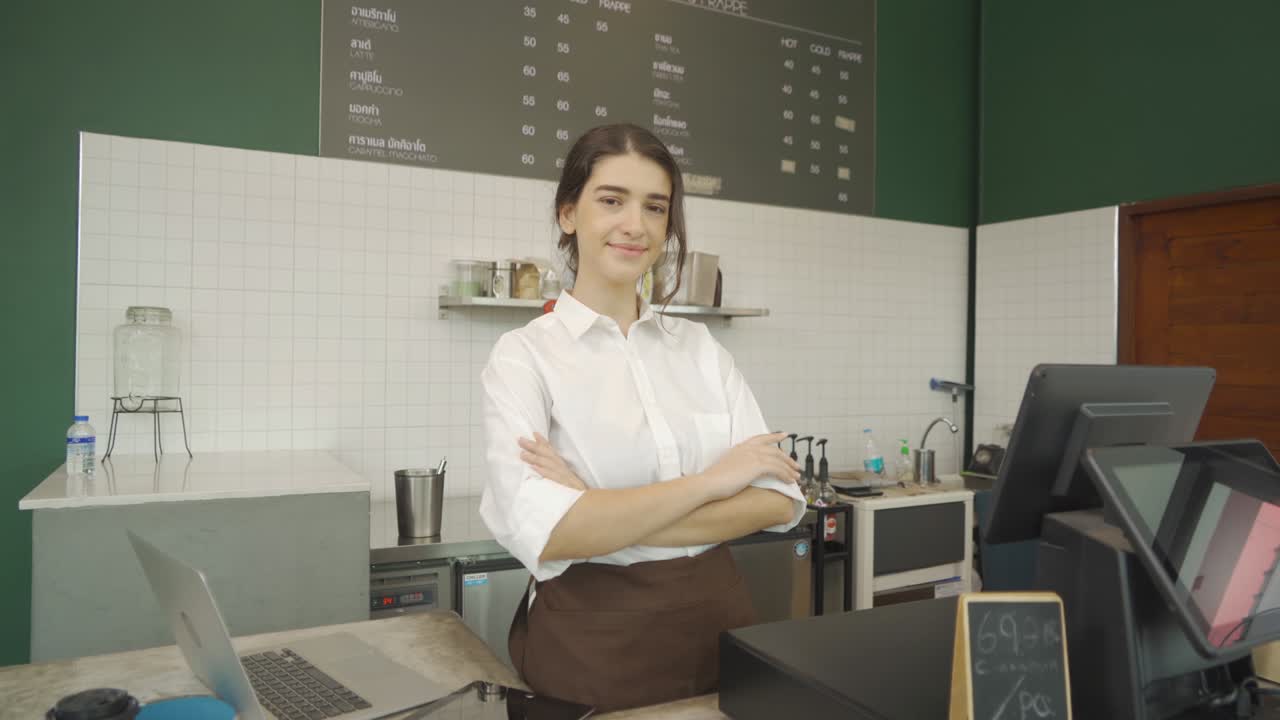 retrato de sonriente joven feliz mujer de oriente medio camarera con delantal de pie con los brazos cruzados, cafetería cajero camarera en la cafetería. estilo de vida de la gente. servicio de negocios.