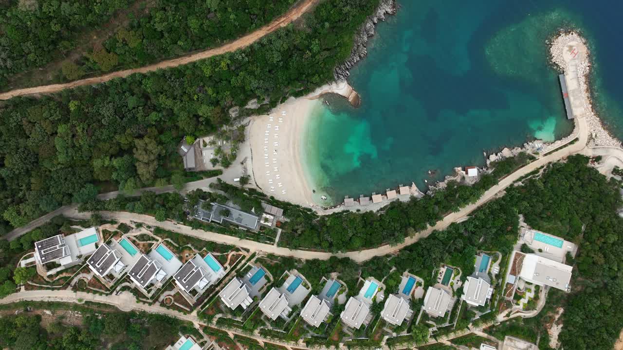 Beautiful top-down view of a hotel resort on a white beach with cozy houses in Saranda, Albania.