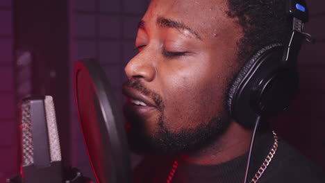 man singing into microphone in a recording studio