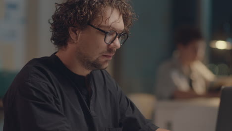 man working on laptop during night in office