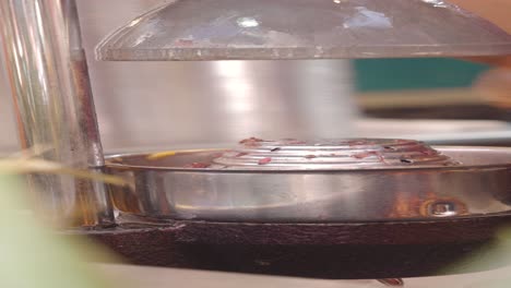 close-up of a hand pressing a fruit in a juicer