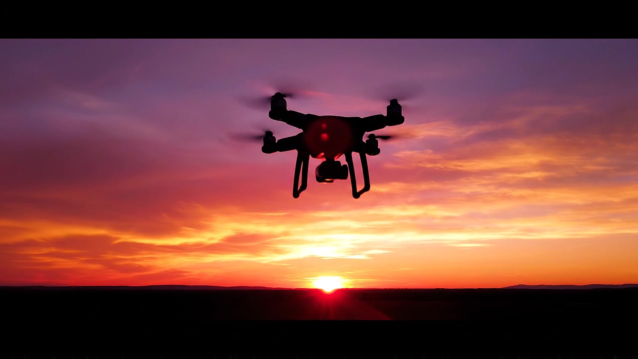 Silhouette di un drone che vola contro un cielo vibrante al tramonto