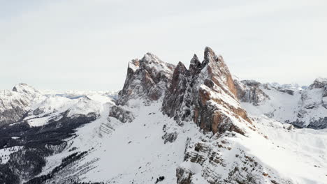 toma aérea que se eleva sobre los picos cubiertos de nieve de los dolomitas italianos en un soleado día de invierno