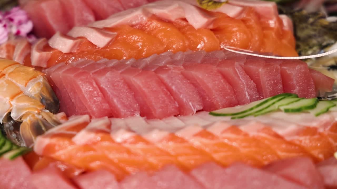 A close-up view of assorted sushi and sashimi with fresh oysters and cucumber slices.