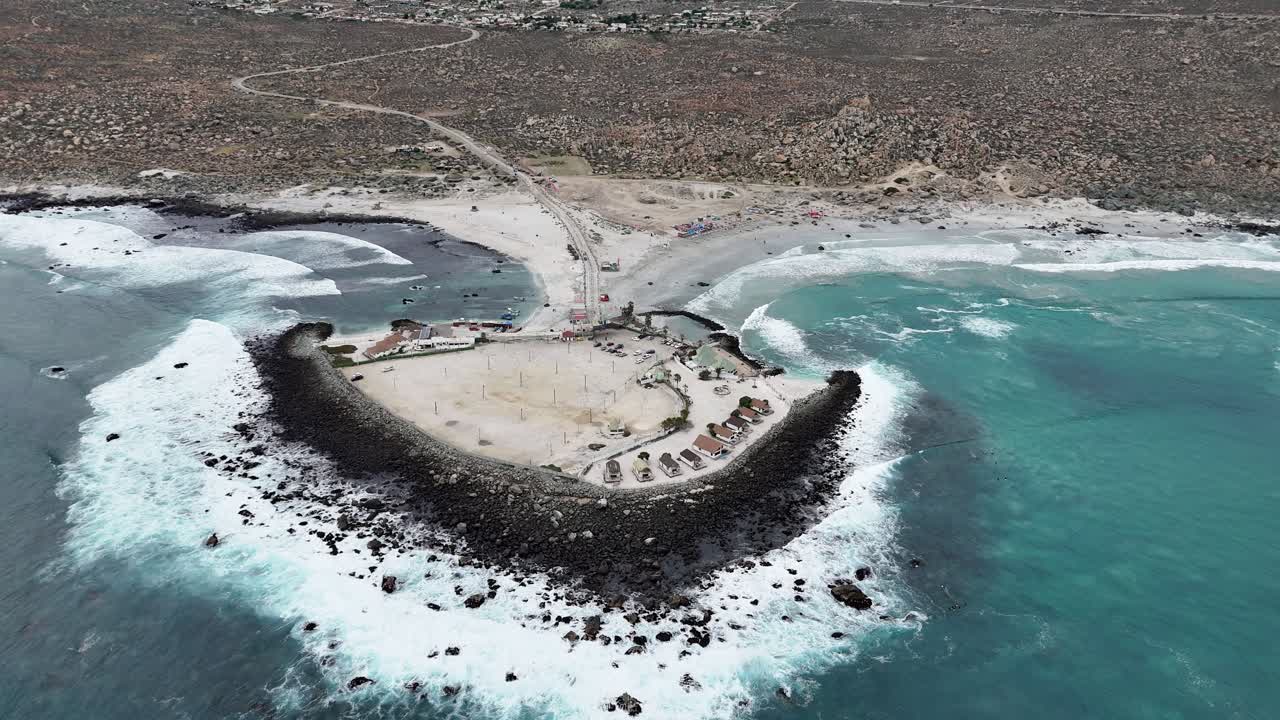 Aerial View of a Rocky Coastal Peninsula and Beach with Turquoise Water