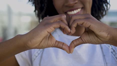 closeup view of female hands making heart shape.