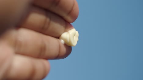 hand holding a blob of cream