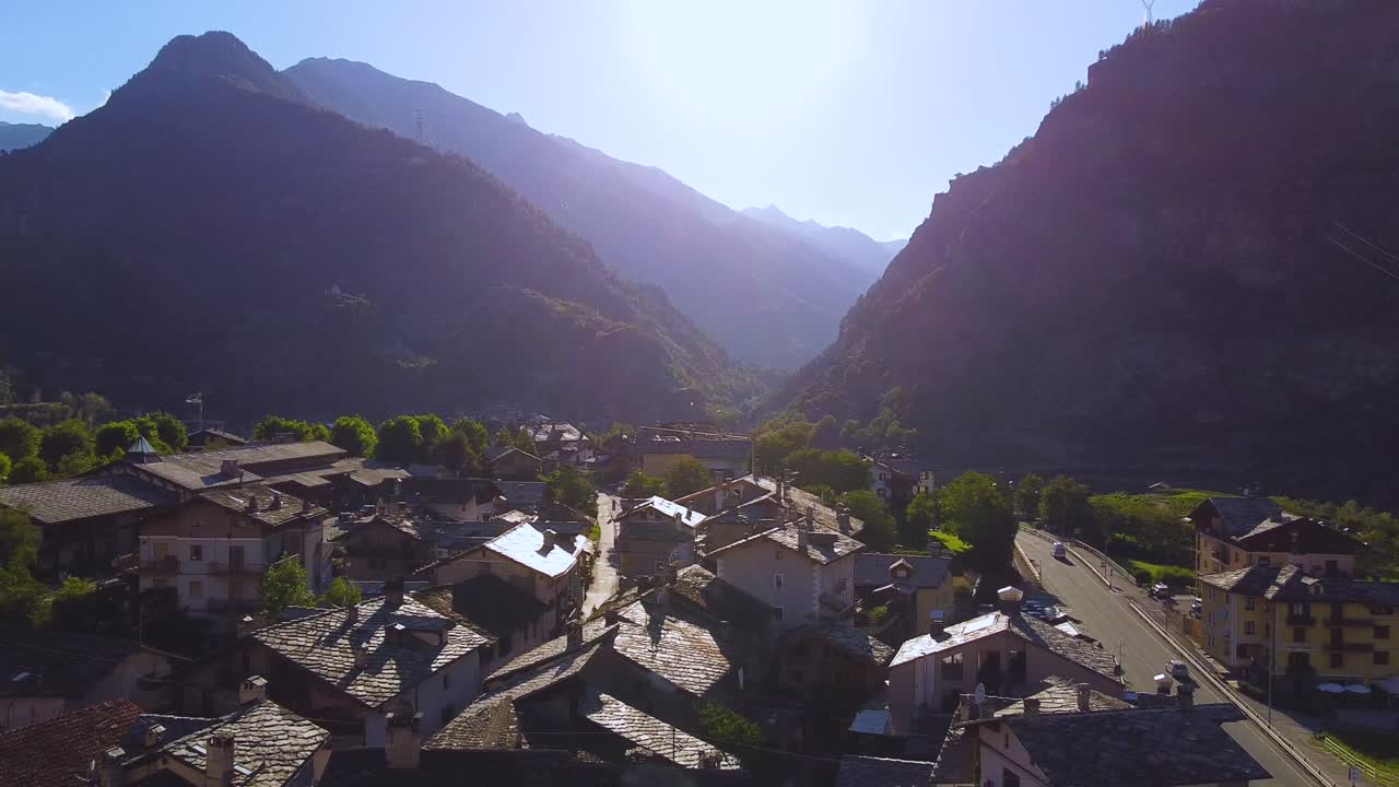 Villaggio alpino italiano in una giornata di sole, vista aerea con drone con movimento verso destra