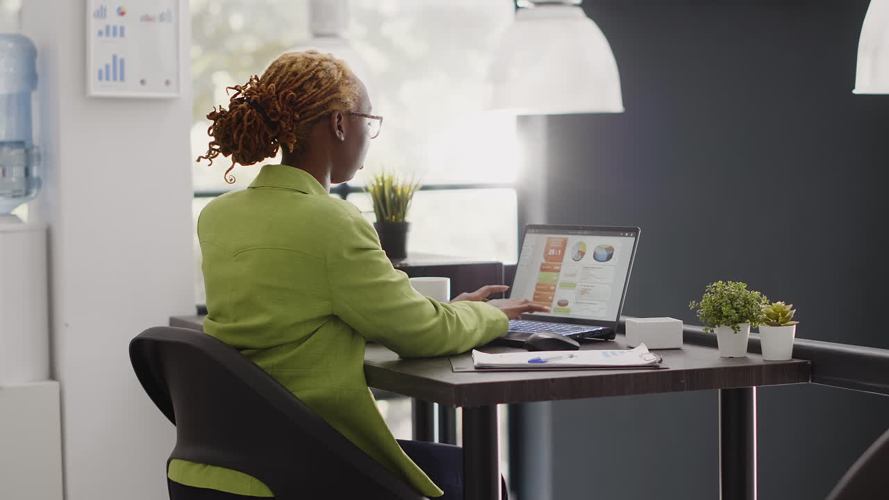 A woman sitting at a table working on a laptop