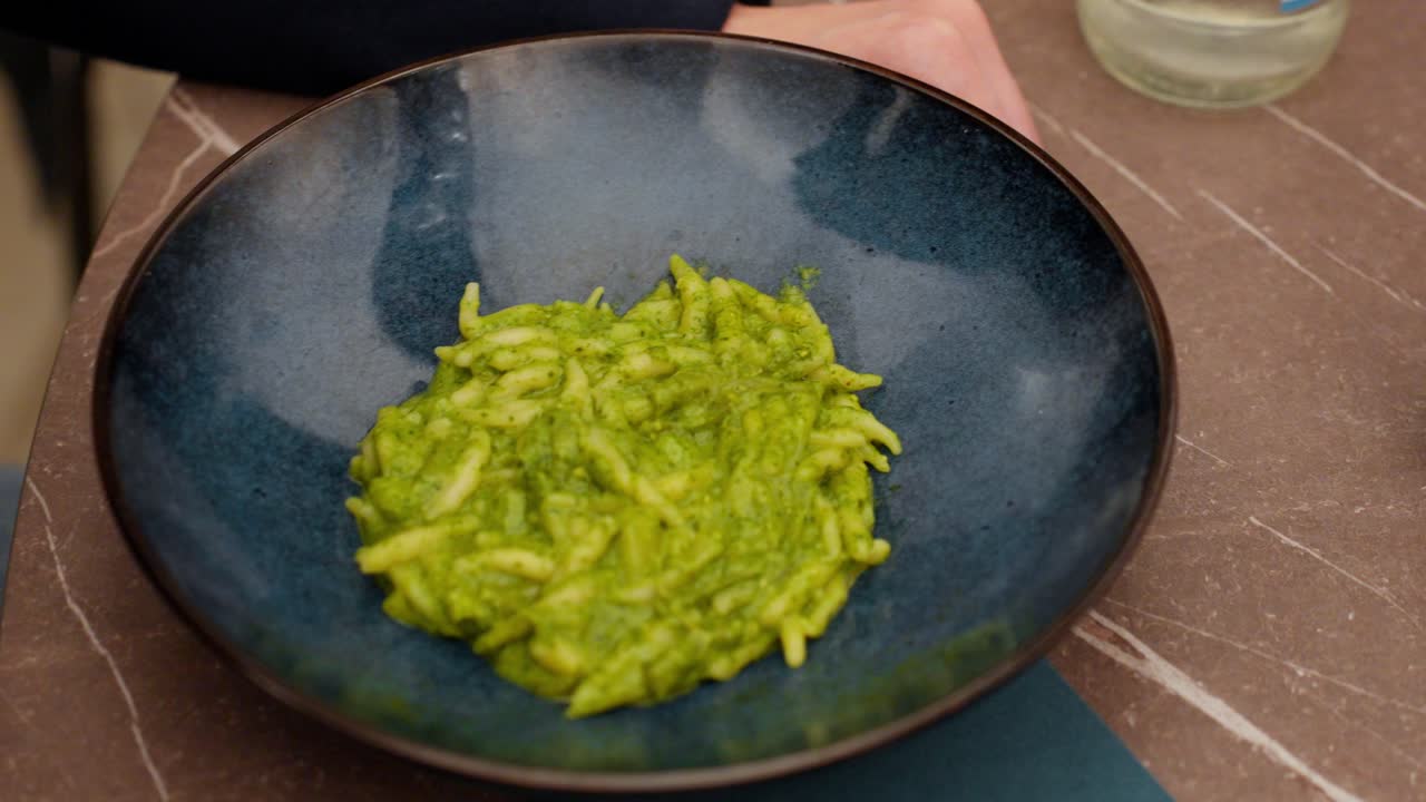 Close-up of pasta with pesto in a bowl, showcasing a typical Genoa dish