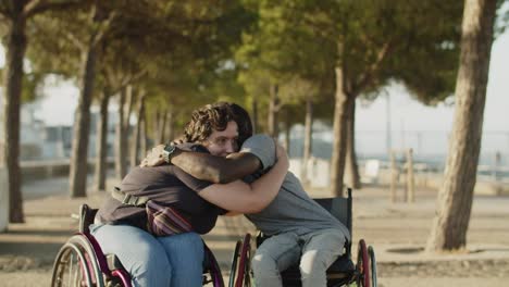 happy couple using wheelchairs hugging in park