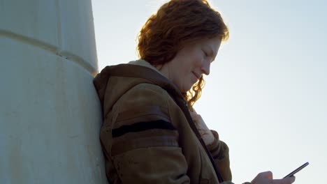 mujer usando teléfono móvil en el muelle 4k