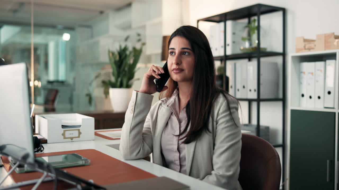 Mujer de negocios hablando por teléfono en una oficina moderna