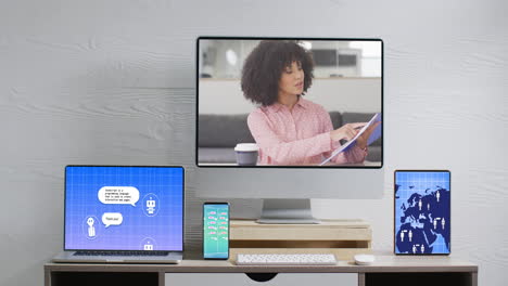 biracial businesswoman on video call and electronic devices with network and ai messaging on screens