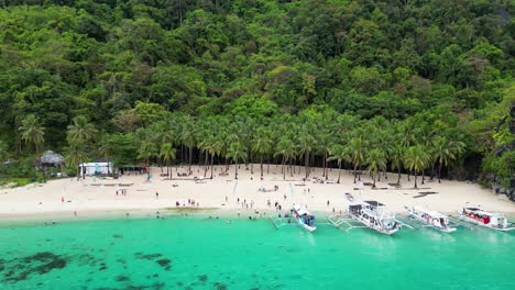 Touristen-Kommen-Auf-Auslegerkanus-An-Und-Entspannen-Sich-Am-Sandstrand-Von-El-Nido-Auf-Palawan