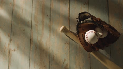 overhead studio baseball still life with bat ball and catchers mitt on aged wooden floor